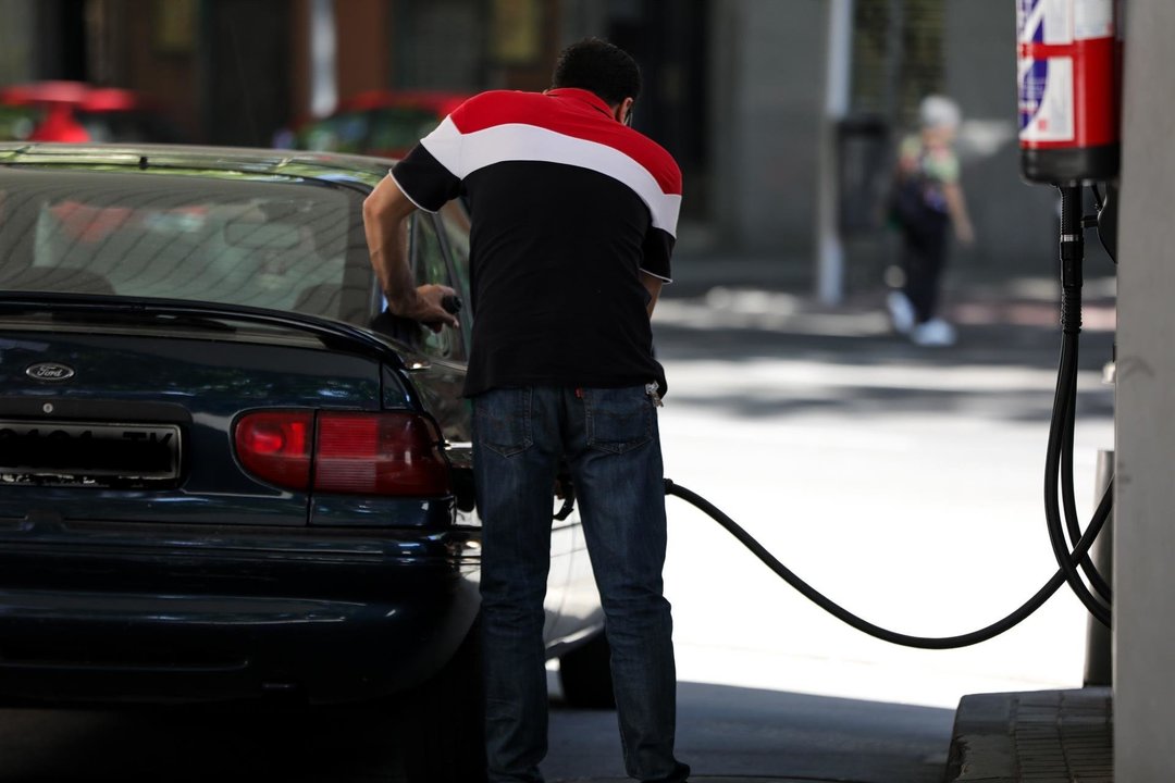 Personas ponen gasolina en sus coches en una gasolinera de Madrid.
