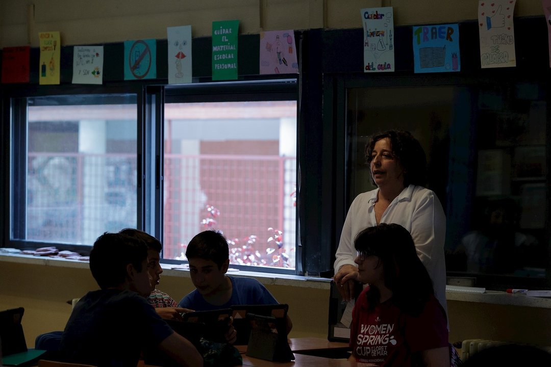 Una profesora imparte una clase en el aula de un colegio.