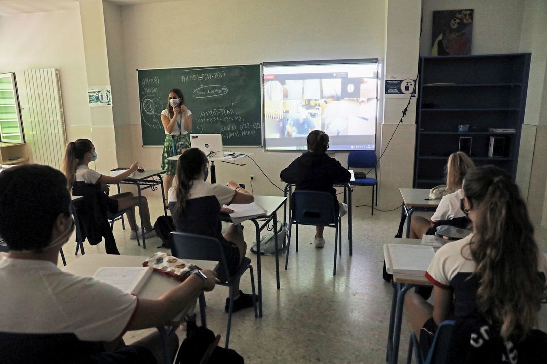 Una profesora y alumnos en una clase.
