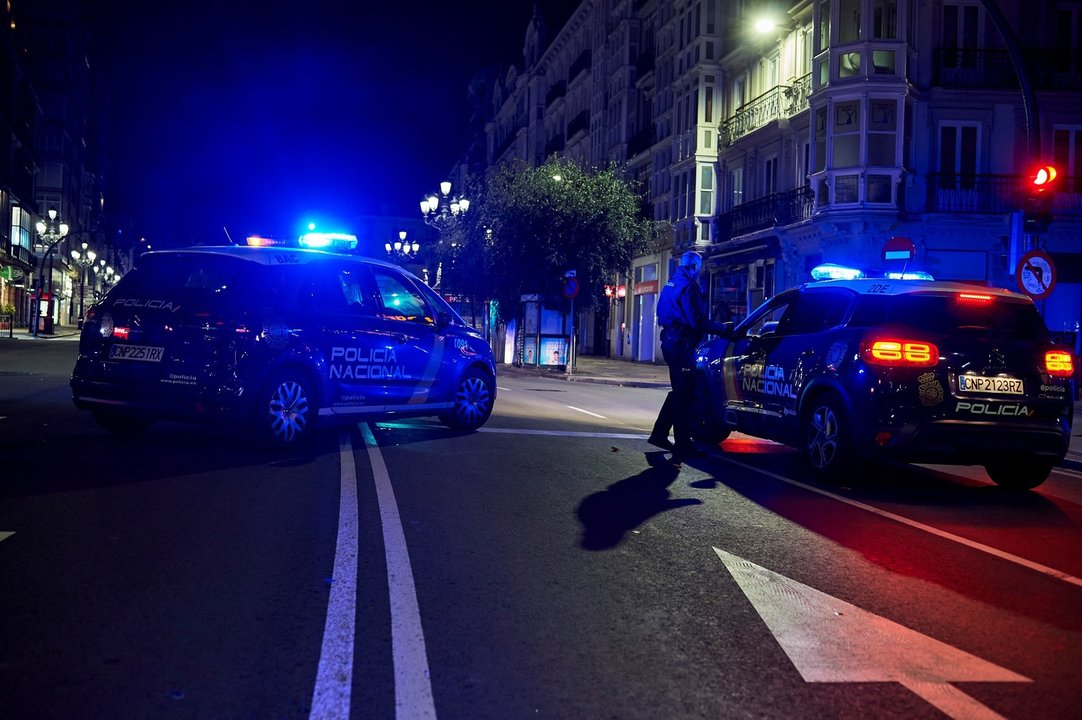 Archivo - Dos coches de Policía Nacional vigilan el cumplimiento del toque de queda en Cantabria